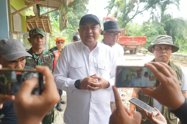 Bupati Bogor Rudy Susmanto saat meninjau perbaikan jembatan amblas imbas diterjang banjir di Citeureup, Minggu, 2 Maret 2025. Rudy Susmanto menyurati BNPB untuk meminta bantuan modifikasi cuaca untuk meminimalisasi bencana. (Arifin/Metropolitan)
