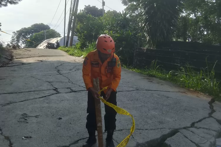 Petugas BPBD memasang danger line di lokasi pergerakan tanah di Desa Bojongkoneng, Kecamata Babakanmadang, Kabupaten Bogor. (BPBD)