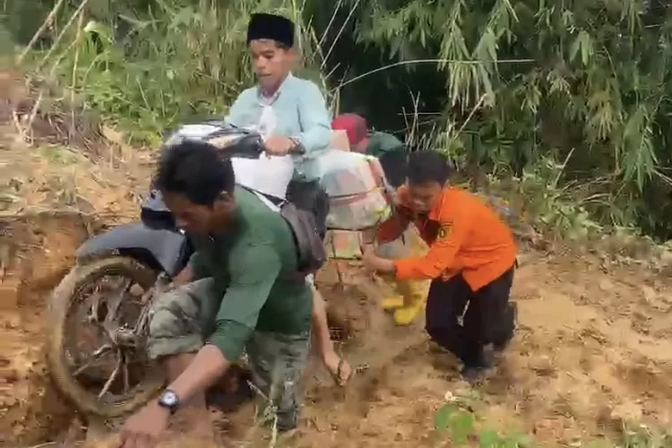 Warga Kampung Mulyasari, Desa Sukamulya, Kecamatan Sukamakmur, Kabupaten Bogor, menerjang akses jalan yang terputus akibat longsor untuk mencari kebutuhan sehari-hari. (Ist)