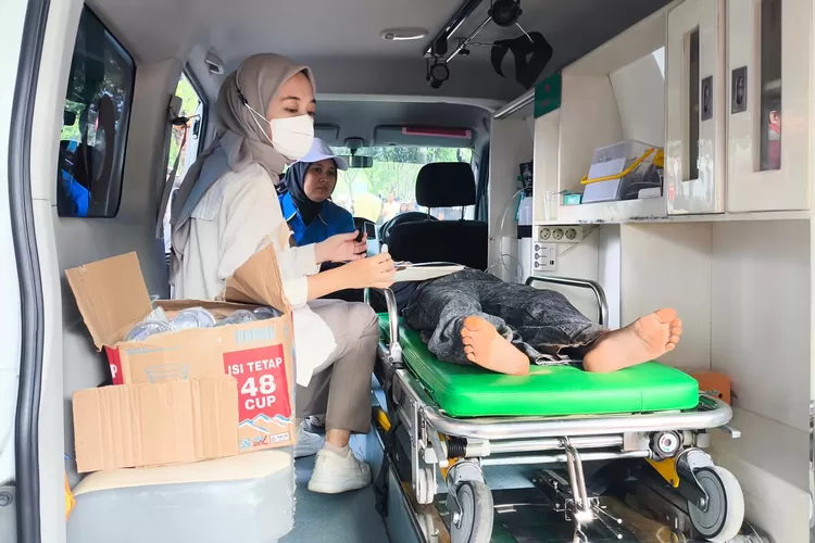 Petugas kesehatan menangai warga yang pingsan saat acara halal bi halal dan mancing massal KNPI dan Karangtaruna Kabupaten Bogor&nbsp;di Situ&nbsp;Gedung Kesenian, Kecamatan Cibinong, Kabupaten Bogor, Minggu 13 April 2025. (Panca)