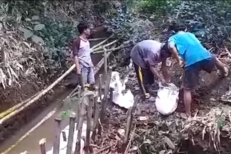 Warga Desa Sukaharja, Kecamatan Ciomas, Kabupaten Bogor, saat memperbaiki irigasi yang rusak. (Ist)