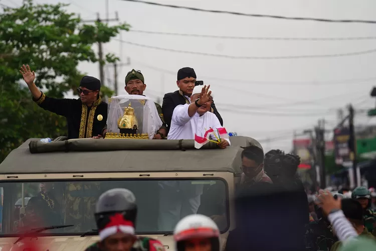 Bupati Bogor Rudy Susmanto bersama Radya Anom Sumedang Larang menyapa warga saat Kirab Mahkota Binokasih dari Karadenan menuju Gedung Tegar Beriman, Cibinong, Kabupaten Bogor, Senin, 21 April 2025. (Arifin - Metropolitan)