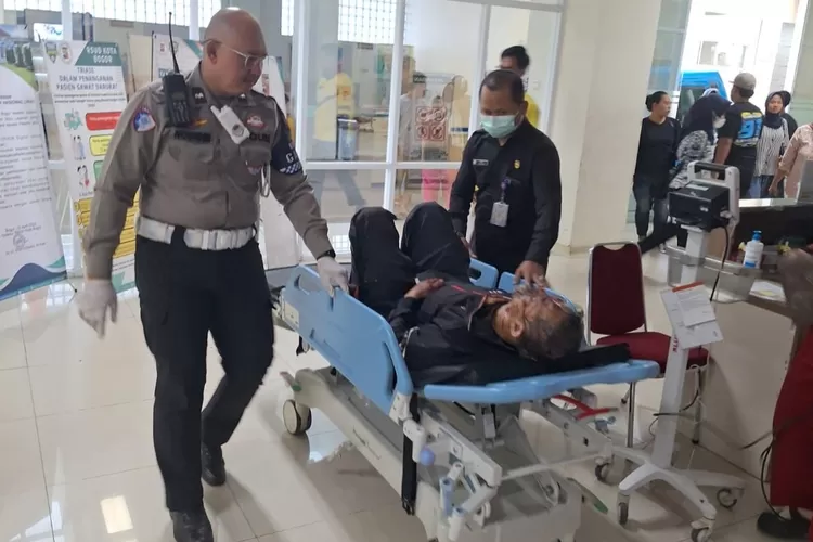 Petugas kepolisian mengevakuasi korban kecelakaan tunggal di Kota Bogor. 