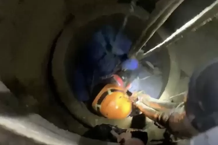 Petugas Damkar mengevakuasi pria yang terjebak di dalam sumur di Puncak Bogor. (Damkar)