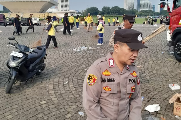 Petugas kepolisian membersihkan lokasi acara May Day Fiesta di kawasan Monas, Jakarta. 