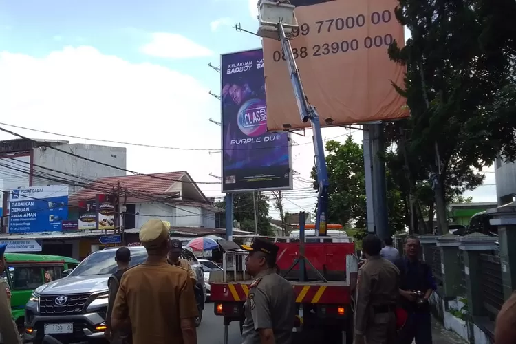 Satpol PP dan Damkar Kota Sukabumi saat menertibkan reklame tak berizin. (UM)