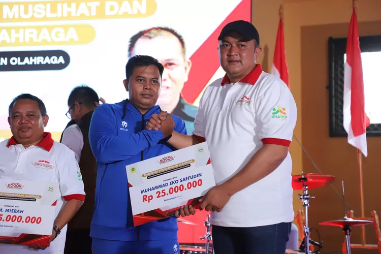 Bupati Bogor Rudy Susmanto saat menyerahkan penghargaan kepada atlet berprestasi di Lapangan Tenis Kapten Muslihat Pakansari, Cibinong, Kabupaten Bogor, Selasa, 13 Mei 2025. (Diskominfo)