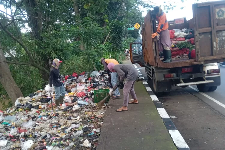 Petugas DLH Kabupaten Bogor saat membersihkan sampah di tepi Jalan Raya Bogor - Jakarta, Kecamatan Sukaraja, Kabupaten Bogor, Selasa, 20 Mei 2025. (DLH)