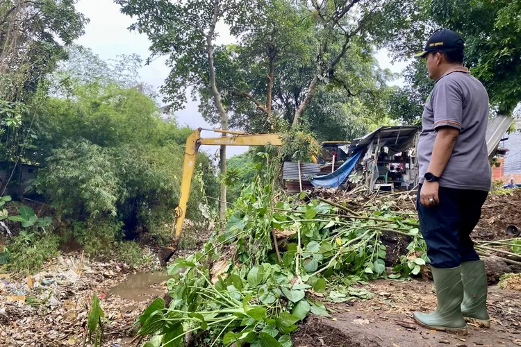 Camat Cibinong Acep Sajidin saat memantau aksi bersih-bersih Kali Baru di Jalan Raya Bogor - Jakarta, Cibinong, Kamis, 22 Mei 2025. (Arifin - Metropolitan)
