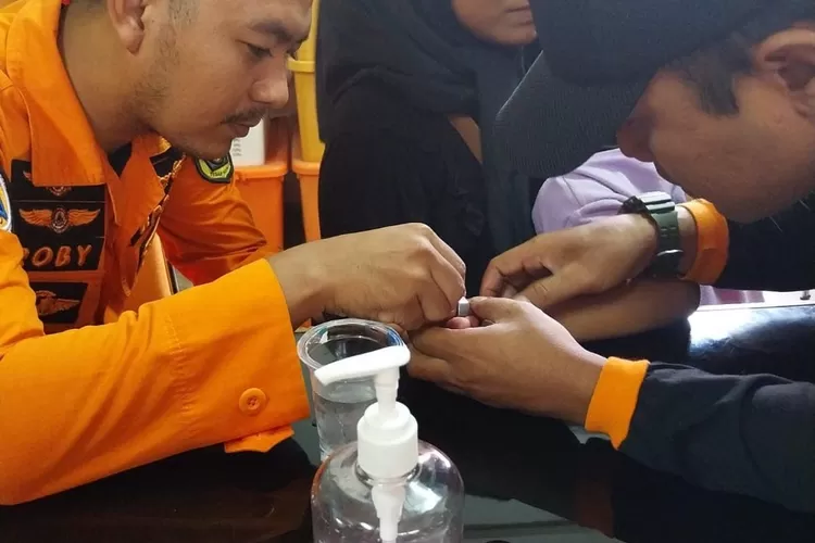 Petugas BPBD Kabupaten Bogor saat melepaskan mur yang menyangkut di jari manis bocah lima tahun. (BPBD)