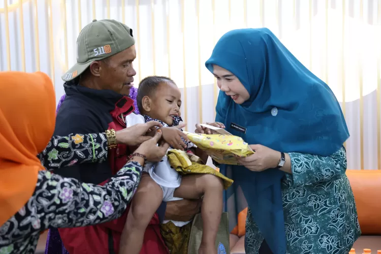 Ketua TP PKK Kabupaten Bogor Eva Marthiana memberikan kado untuk anak yang mengikuti khitanan massal di RSUD Idham Chalid Ciawi, Kabupaten Bogor, Jumat, 21 Juni 2025. (Diskominfo)