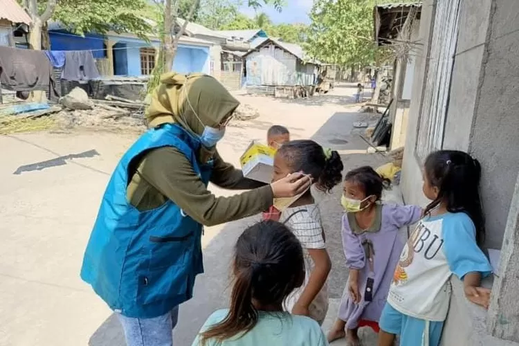 Anak-anak mengenakan masker sebagai perlindungan saat erupsi Gunung Lewotobi Laki-laki terjadi.