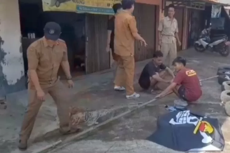 Tangkapan layar petugas Pemdes Neglasari bersama warga menurunkan bendera One Piece yang berkibar di Jalan Cibeureum, Dramaga, Kabupaten Bogor. 