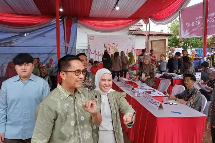 Ratu Dewa didamping sang istri menyalurkan hak pilihnya di TPS 028 Kancil Putih, Kelurahan Demang Lebar Daun, Rabu (27/11/24) pagi. (Dok Ist/KetikPos.com)