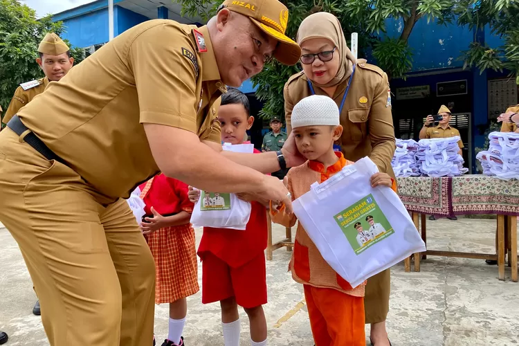 Sekda Palembang menyerahkan seragam gratis (dok)