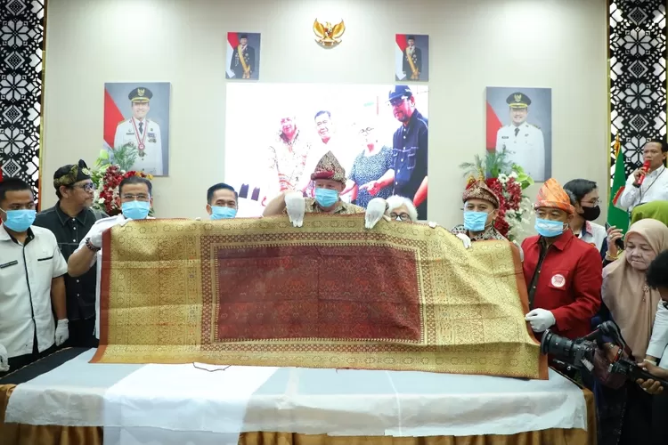 Sarung tangan dan masker dipakai saat menampilkan songket kuno di rumah dinas walikota Palembang. (Dok)