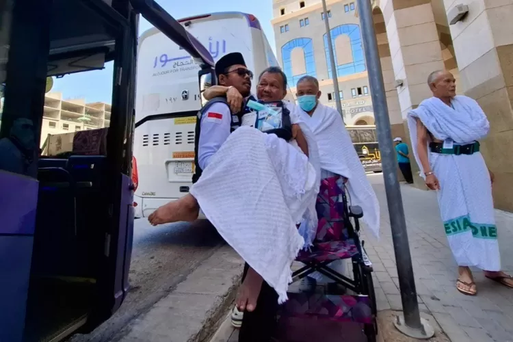 (Ilustrasi) Petugas Haji menggendong jemaah masik kedalam bus - Foto: Henri Lukmanul Hakim