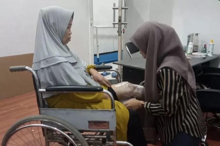 Tim Lembaga Amil Zakat Persatuan Islam (LAZ PERSIS) memasangkan kaki palsu untuk Bu Ayi - Foto: Istimewa