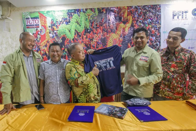 Ketua PFI Tangerang, Dery Ridwansah memberikan kaos berlogo PFIT Goes To Campus kepada Rektor UMT, Desri Awen - Foto: Henri Lukmanul Hakim