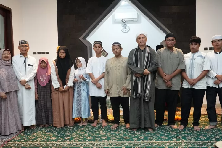 Habib Umar Assegaf, Muhammad Aqil Irham dan Yuliati Aqil Irham bersama para santri dan anak yatim usai pembacaan Maulid al Barzanji, tausiyah dan doa bersama untuk korban bencana alam Sumatera, di Musholla Al Ikhlas, Kelapa Dua Wetan, Ciracas Jakarta Timur, Rabu (17/12/2025)