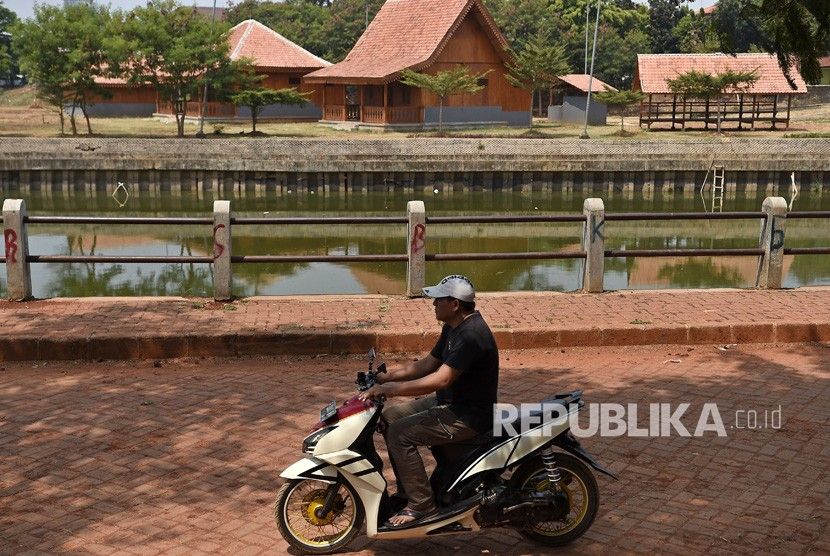 Warga melintasi kawasan replika perkampungan tempo dulu di Zona C Perkampungan Budaya Betawi Setu Babakan, di Srengseng Sawah, Jagakarsa, Jakarta Selatan, Kamis (8/8/2019). Pemprov DKI Jakarta menyempurnakan replika perkampungan Betawi tempo dulu di pulau di tengah Danau Setu Babakan dengan membuat sawah, kubangan kerbau, kebun dan kolam ikan, yang ditargetkan menjadi destinasi baru pada 2020. ANTARA FOTO/Aditya Pradana Putra/ama.