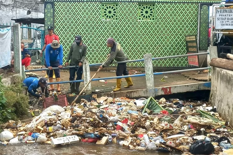 RUTINITAS : Sargas DLHK Kota Depok saat mengangkut sampah di Kali Licin yang mengalir menuju Kelurahan Mampang, Kecamatan Pancoranmas.  (RISKY DWI LESTARI/RADAR DEPOK)