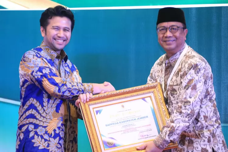 Kepala Bappeda Kabupaten Jember, Arief Tyahyono saat menerima penghargaan dari Plt. Gubernur Jawa Timur, Emil Elestianto Dardak.   (Diskominfo Jember)
