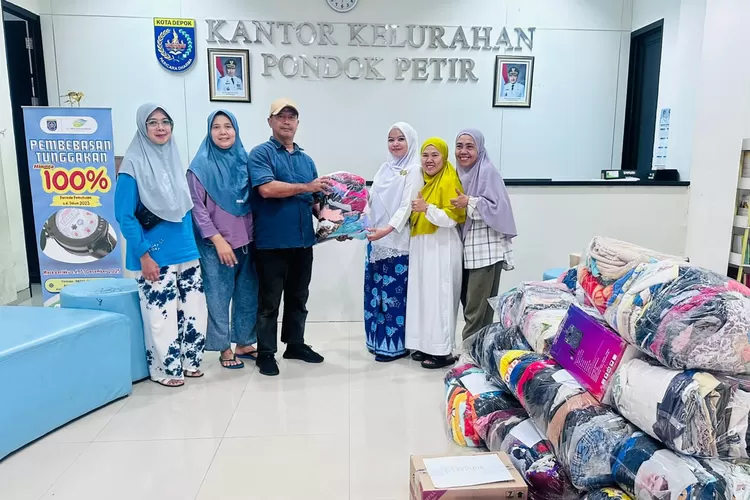 Ketua RW16 Kelurahan Pondok Petir, Suwanto (Baju biru topi cream) saat menyerahkan langsung hasil penggalang dana donasi dari wargw RW16 dan pakaian layak paka. (RISKY DWI LESTARI/RADAR DEPOK)