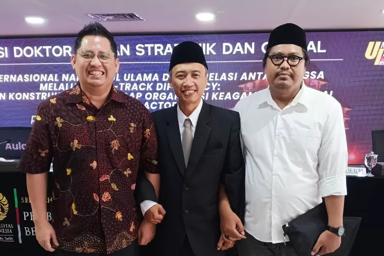 Ketua PCNU Kota Depok, KH Achmad Solechan (tengah) didampingi Sekretaris DPD PSI Kota Depok, Marthin Jonathan Gultom, selepas sidang Doktoral di UI, Rabu (10/12). ( ist)