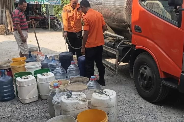 Petugas BPBD Kabupaten Bogor mengisikan air ke jerigen warga Jonggol.    (KABAR BOGOR )