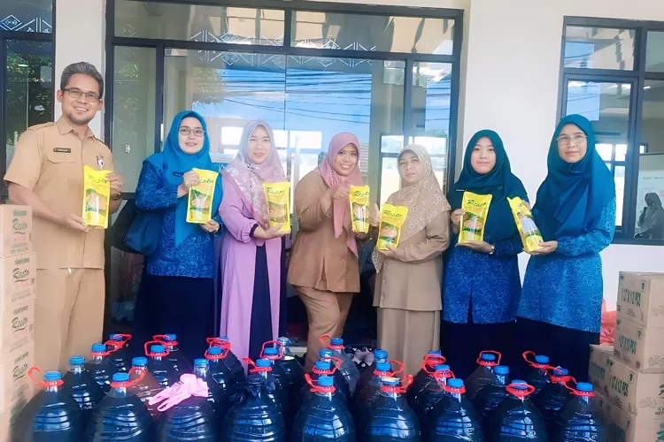 Sekretaris Kelurahan Serua, Komarudin (kiri) dan PKK Kelurahan Serua saat memegang minyak bersih 1 Liter dan mengumpulkan minyak jelantah dalam program Sera Mijel, di kantor Kelurahan Serua, Kecamatan Bojongsari, Senin (30/6).  (RISKY DWI LESTARI/RADAR DEPOK)