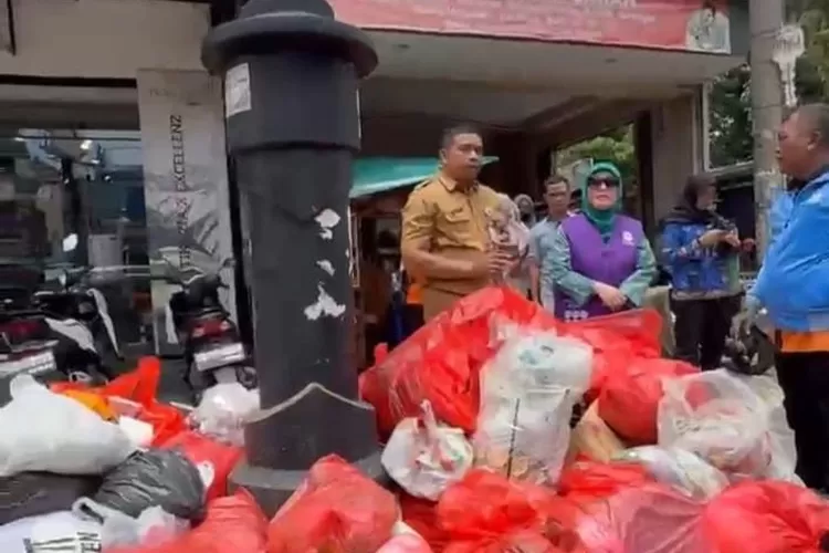 Kepala Seksi Pemerintahan Kelurahan Pondok Cina, Ahmad Sutisna mendampingi TP PKK Kota Depok dan DLHK Kota Depok, Senin (10/11). (RISKY DWI LESTARI/RADAR DEPOK)