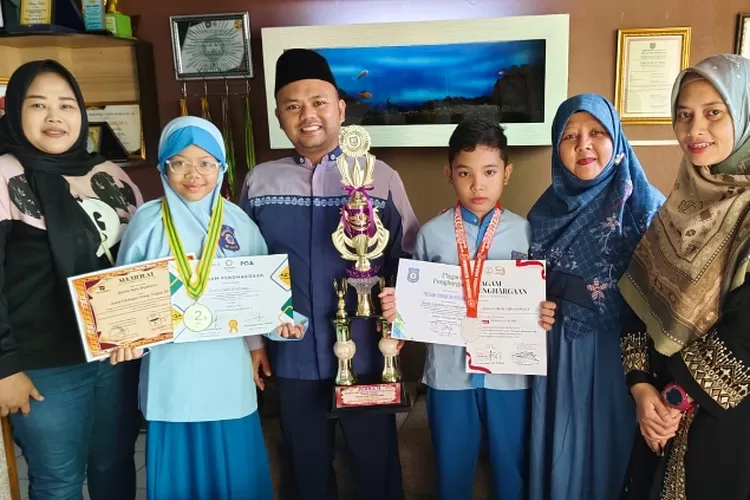 Keisha Aqila Wijaksono dan Novan Omar Ahmadimas, siswa SD Muhammadiyah Meruyung meraih jaura tingkat Nasional, yang diapresiasi Kepala SD Muhammadiyah Meruyung, Ade Irma Gunawan. (RADAR DEPOK&nbsp;)