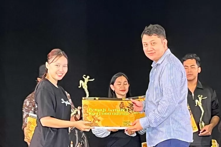 Wakil Rektor III UWM Dr. Roni Sulistyanto Luhukay, S.H., M.H.  menyerahkan hadiah berupa uang pembinaan kepada kontingen Kabupaten Bantul berhasil menjadi juara dalam Festival Sendratari DIY 2025 di UWM.  (Foto: Dok. Istimewa)