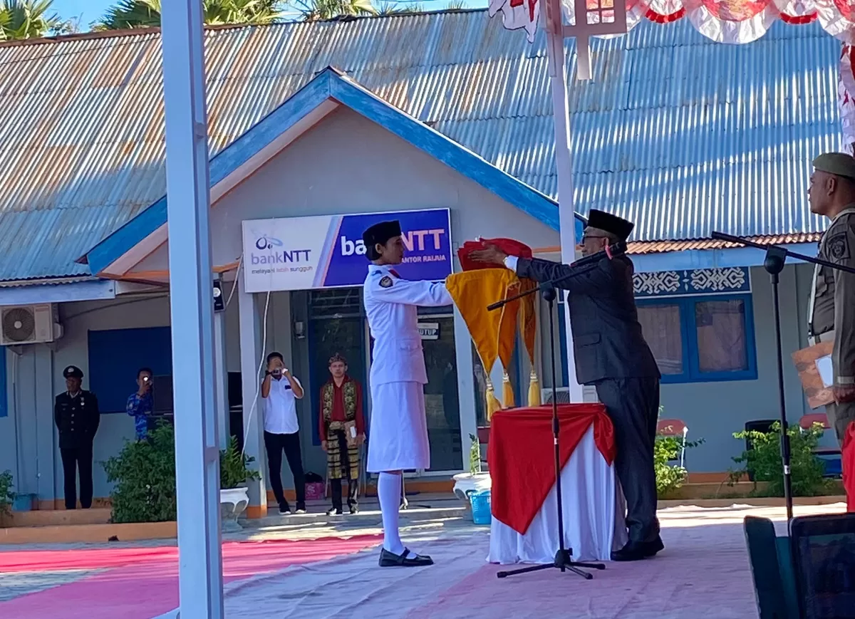 Sekretaris Daerah Kabupaten Sabu Raijua menyerahkan bendera merah putih kepada petugas upacara. (Yongki Pawe Due/SketsaNusantara.id)