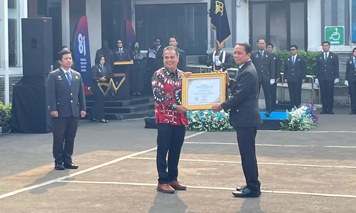 Sekretaris DPRD Kabupaten Cianjur Pratama Nugraha Emmawan menerima penghargaan JDIH Terbaik II Nasional dari Kakanwil Kemenkum Jawa Barat Asep Sutandar di Bandung. (FOTO: Ist)