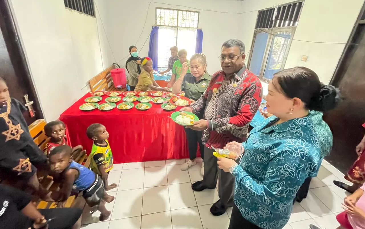 Pj Bupati Jayawijaya Thony M Mayor & PJ Ketua PT PKK Jayawijaya Meitty Mayor saat memberikan makanan tambahan kepada anak-anak di Distrik Wamena kota dalam rangka penurunan angka stunting jumat(24/1). ((Ceposonline.com/DENY))