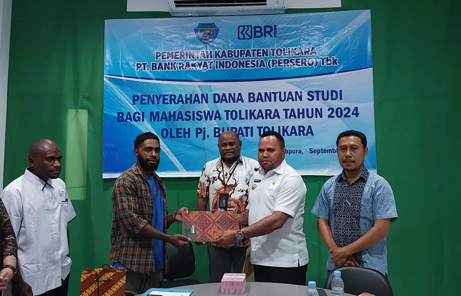 Pj Bupati Tolikara, Marthen Kogoya, saat serahkan secara simbolis bantuan beasiswa perwakilan Mahasiswa Asal Tolikara di Kota Studi Jayapura, di Kantor BRI Cab. Abepura, Rabu (4/9/2024).  ((Ceposonline.com/Karel))