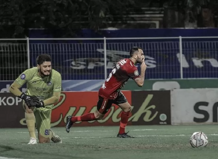 Kiper Arema FC Adilson Maringa (kiri) setelah gagal mengantisipasi eksekusi penalti Brwa Nouri yang selebrasi merayakan gol perdananya bersama Bali United musim 2021-2022.