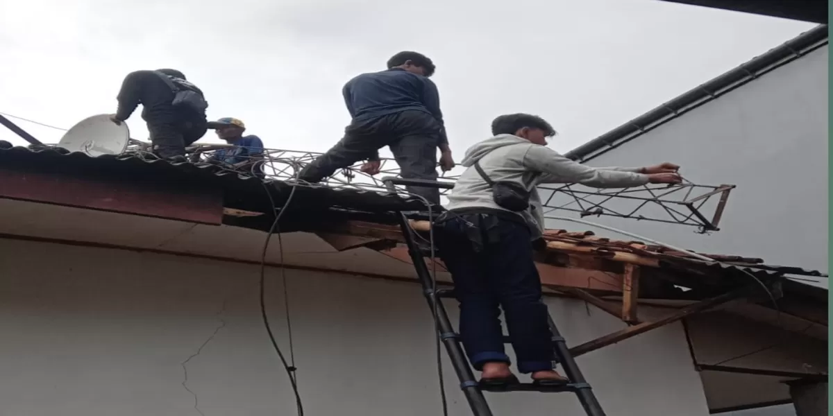 Petugas dan warga mengevakuasi rumah yang tertimpa tiang provider roboh di Desa Ciadeg, Cigombong. (Ist)