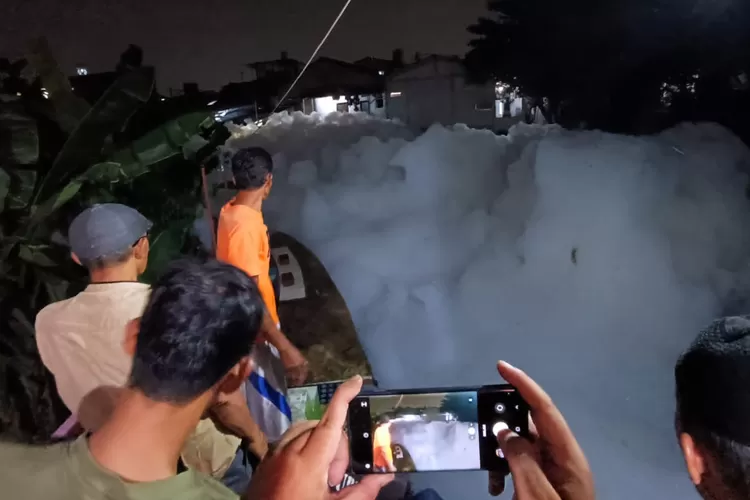 Limbah busa menutupi aliran Sungai Kali Baru hingga tingginya menutup rumah di Kampung Curug RT4/1 Kelurahan Tugu, Cimanggis, Depok, pada Senin (27/11). (YUSUF/RADAR DEPOK)
