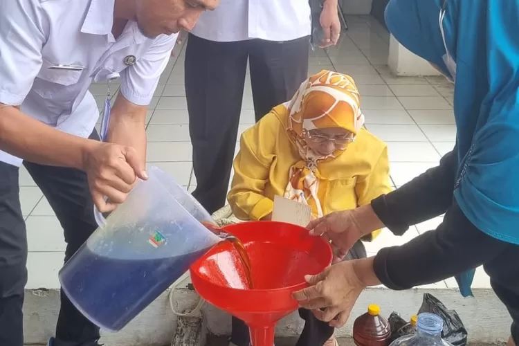 Kasi Kemasyarakatan dan Pelayanan Kelurahan Pasir Putih, Supriyadi mendampingi langsung prosesi penukaran minyak jelantah (mijel) di Kantor Kelurahan Pasir Putih, Kecamatan Sawangan, Rabu (26/11). (RISKY DWI LESTARI/RADAR DEPOK)