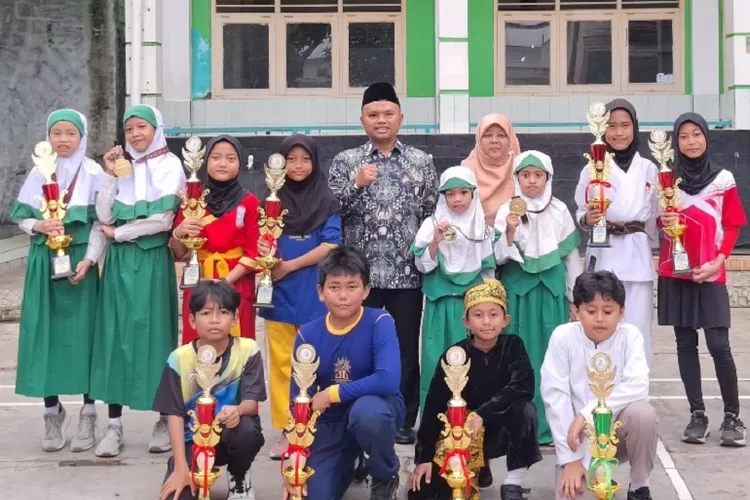 Kepala SD Muhammadiyah Meruyung, Ade Irma Gunawan menyerahkan secara simbolih menyerahkan piala kepada siswa yang meraih juara pencak silat, Senin (20/5). (RADAR DEPOK)