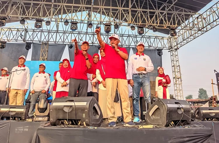 Walikota Depok Mohammad Idris, didampingi Kapolres Metro Depok Kombes Arya Perdana (kanan), dan Wakil Walikota Depok Imam Budi Hartono (kiri) saat menyapa peserta Fun Walk dan Fun Bike dari atas panggung puncak perayaan HUT ke 79 RI tingkat Kota Depok di White House, Kelurahan Sukatani.