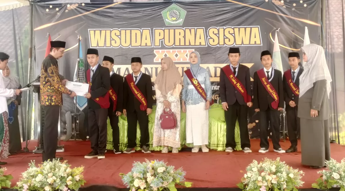 Ketua Yayasan Nurul Jadid Anang Fauzi (kiri) menyerahkan piagam penghargaan kepada perwakilan wisudawan. (SketsaNusantara.id/As'ad Choirudin)