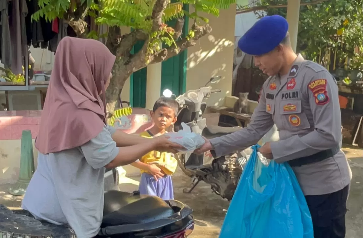 Personel Unit Patroli Satpolairud Polresta Barelang saat membagikan nasi kotak kegiatan Jumat Berkah kepada masyarakat di Pesisir Perairan Tanjung Uma. (Foto: Humas Polresta Barelang)