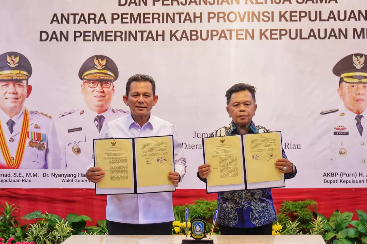 Gubernur Kepri Ansar Ahmad dan Bupati Kepulauan Meranti AKBP (Purn) Asmar menunjukkan dokumen Kesepakatanberupa Perjanjian Kerja Sama di Gedung Daerah, Tanjungpinang.(Foto:Diskominfo Kepri)
