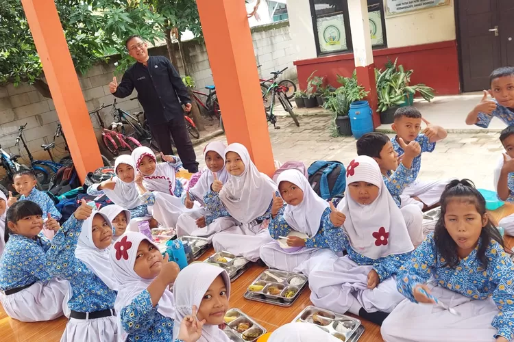 Foto bersama Kepala SDN Cilangkap 3, Heriyadin berasama siswa yang sedang menyantap makan bergizi gratis. (ANDIKA EKA/RADAR DEPOK)