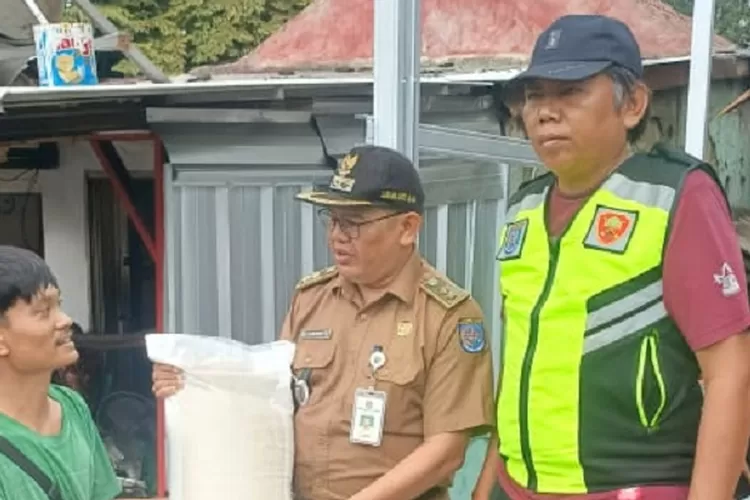 Lurah Jatijajar, Mujahidin saat memberikan bantuan kepada korban dampak kebakaran, di RW 6, Kelurahan Jatijajar, Kecamatan Tapos, Kota Depok, Senin (13/1). (AGNESYA WIANDA/RADAR DEPOK)