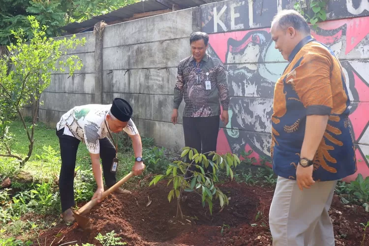 Aparatur Kecamatan Tapos melakukan aksi simbolis penanaman pohon di halaman belakang kantor kecamatan. (ANDIKA EKA/RADAR DEPOK)
